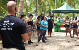 Grupo de jóvenes voluntarios recibiendo indicaciones en una actividad al aire libre.